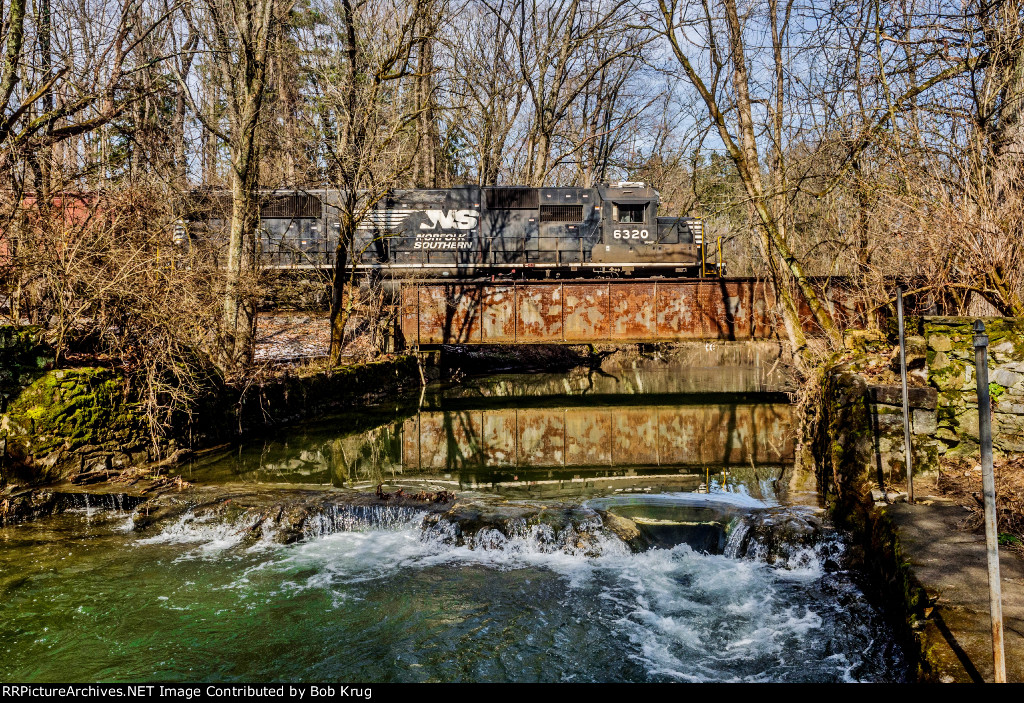 NS 6320 leads H75 across a plate girder bridge in Housenick Memorial Park, Bethlehem Township